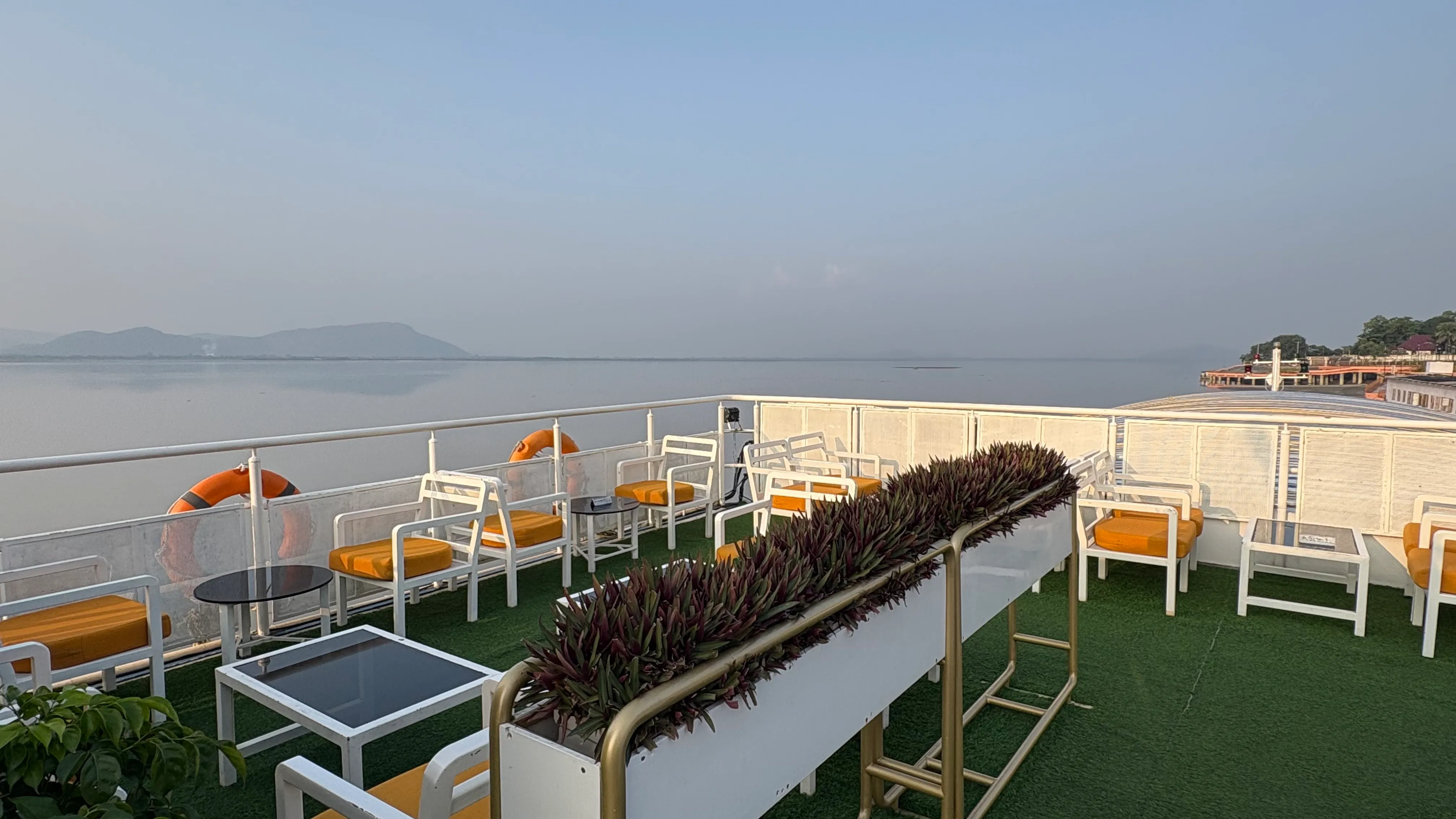 Open-air seating with orange cushions on the upper deck