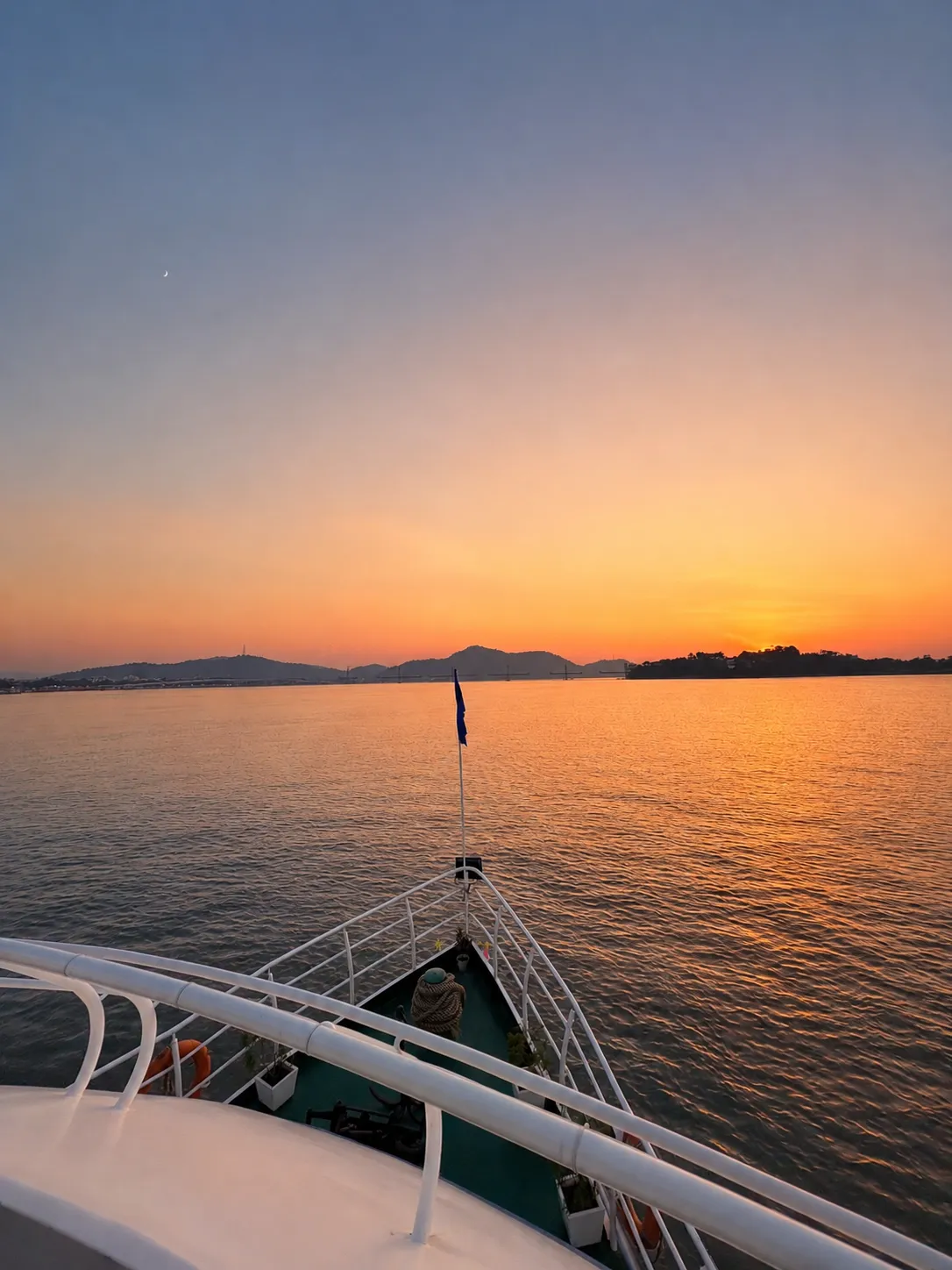 Sunset over the river seen from the bow deck of the cruise