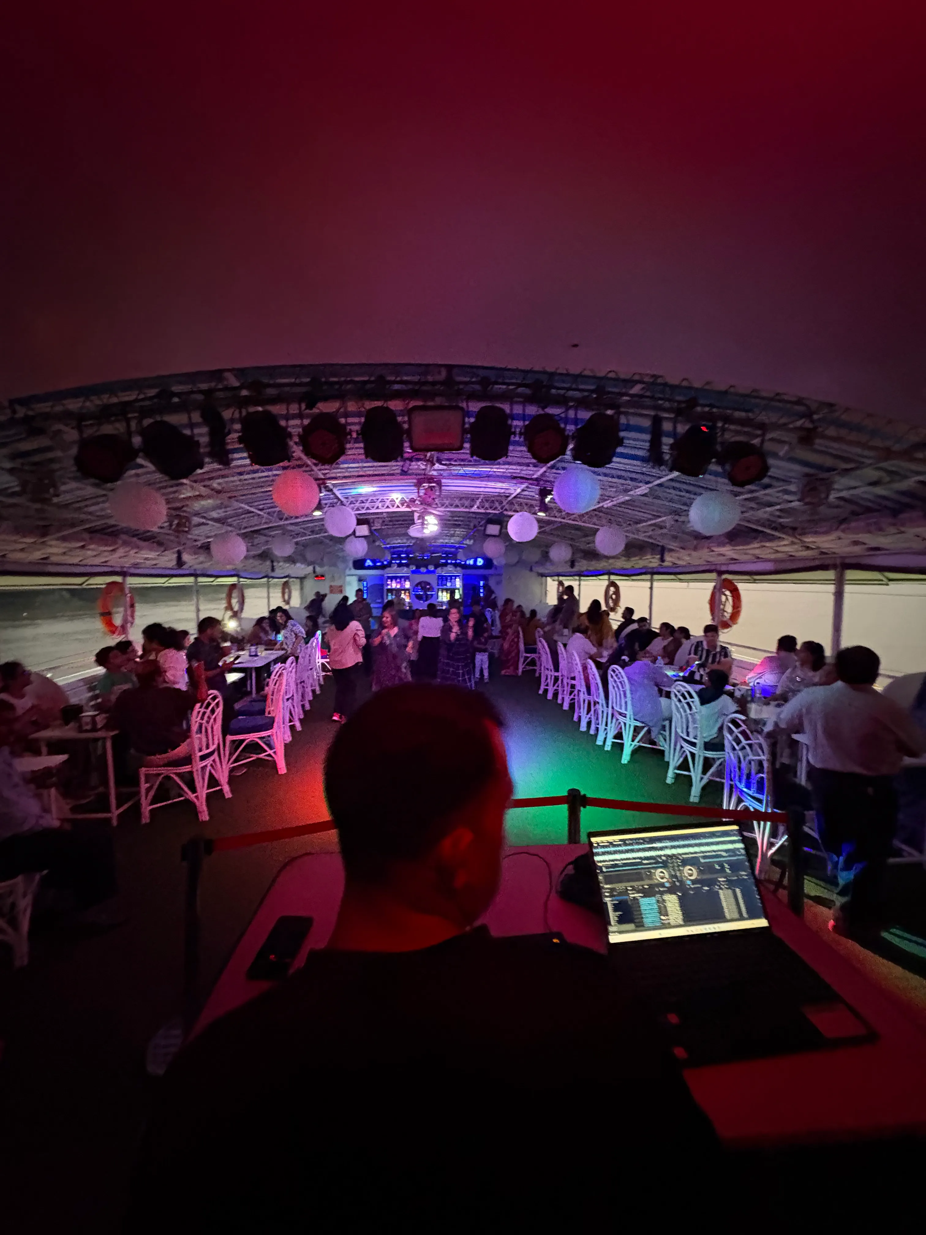 DJ playing to guests on deck during an evening cruise
