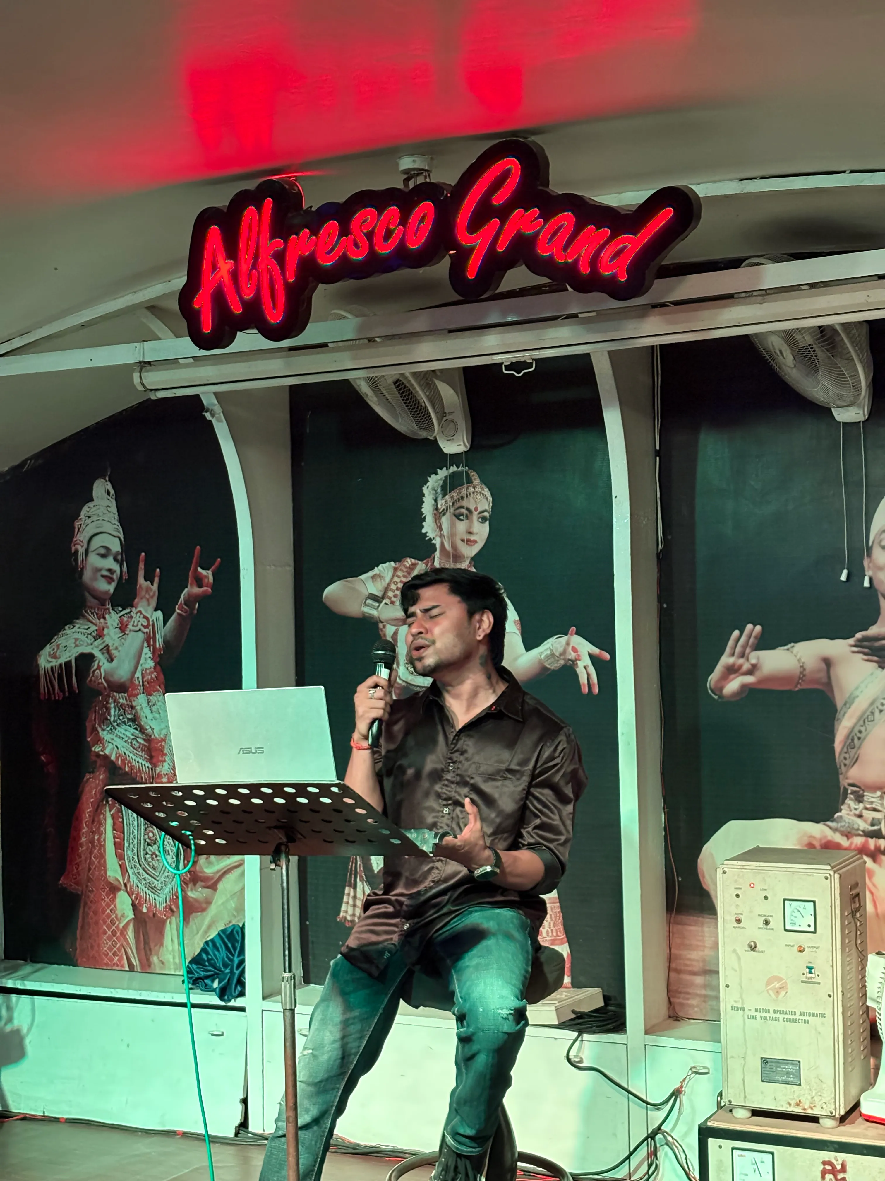 Live singer performing beneath the Alfresco Grand sign
